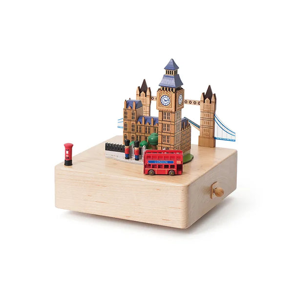 The London Music Box features miniature Big Ben, Tower Bridge, a red double-decker bus, and postbox on a square light wood base. This hand-cranked music box makes a charming decorative piece for any room.