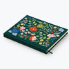 The Strawberry Fields Embroidered Sketchbook is a dark green hardcover journal with vibrant floral embroidery and a black ribbon bookmark.