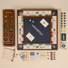 The 3-in-1 Game Collection: Monopoly, Sorry & Mancala is arranged on a beige surface, with game pieces, cards, dice, money, and a reversible board showing the Monopoly logo for family fun.