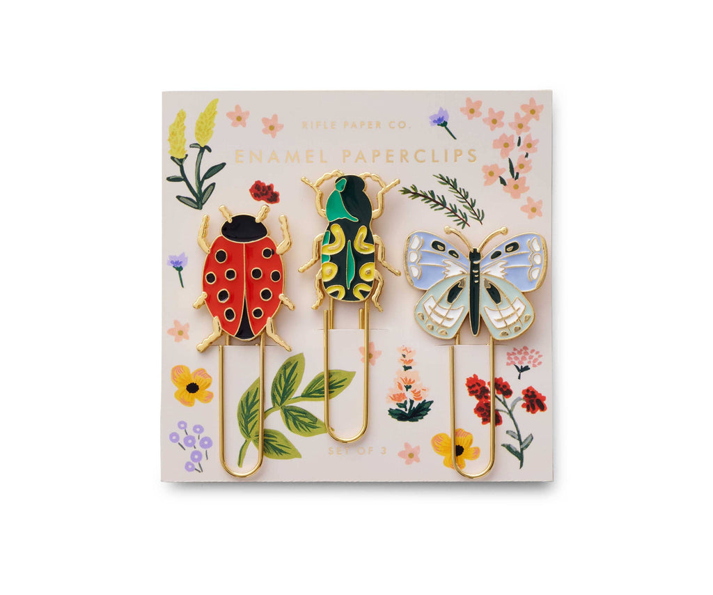 The Curio Enamel Paper Clip Set includes three paperclips shaped like a ladybug, beetle, and butterfly on a floral card labeled "Enamel Paperclips"—a charming accent for your desk or beside any 4 x 4 picture frame.