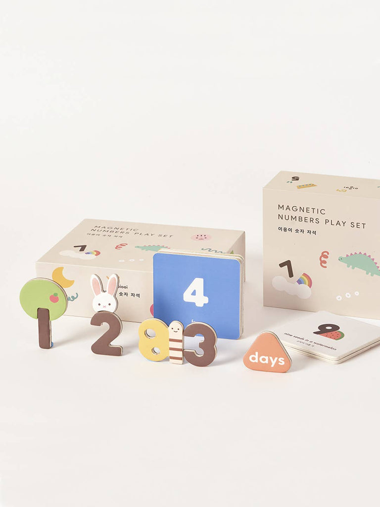 The Magnetic Number Play Set includes colorful numbers 1–4, an illustrated worm and rabbit, a "days" token, and two background boxes. These magnet pieces are arranged on a white surface for playful learning.