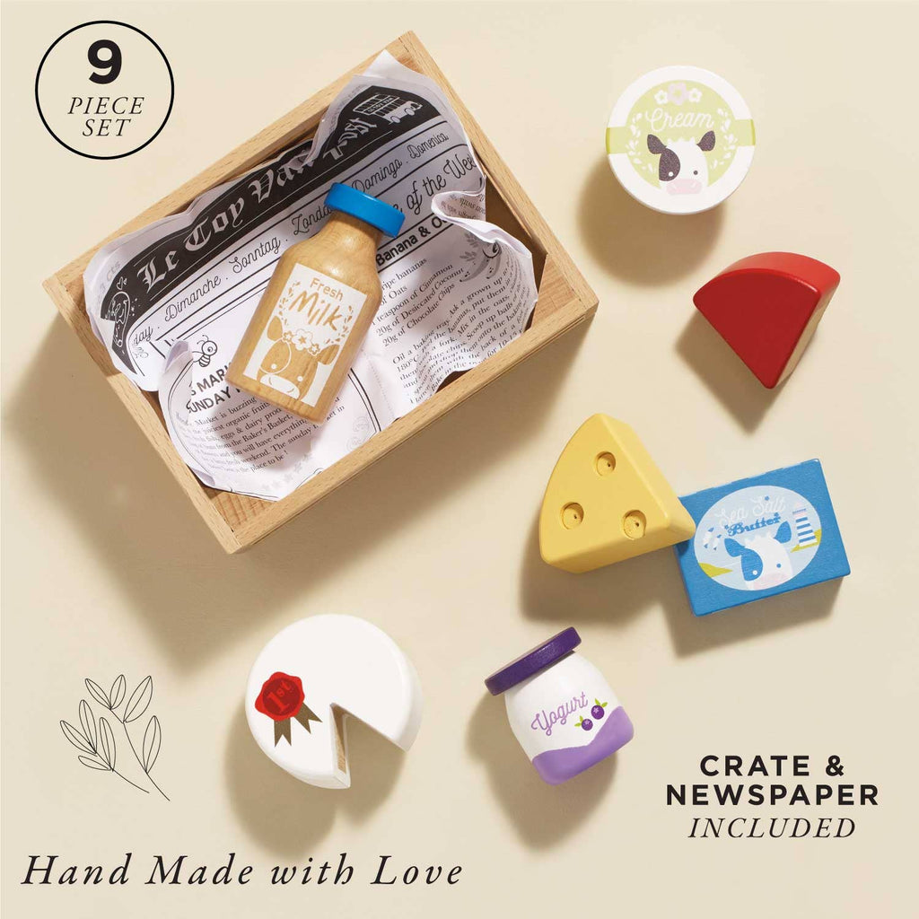 The Cheese & Dairy Wooden Market Crate is a 9-piece wooden pretend play food set with cheese, milk, and jars in a newspaper-lined crate. Includes "Hand Made with Love," "9 Piece Set," and "Cheese and Dairy Crate Included" text—a charming educational toy.
