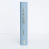 A light blue hardcover collector’s edition stands upright, its spine reading "Pride and Prejudice | Austen" in gold lettering with small decorative designs above and below the title.