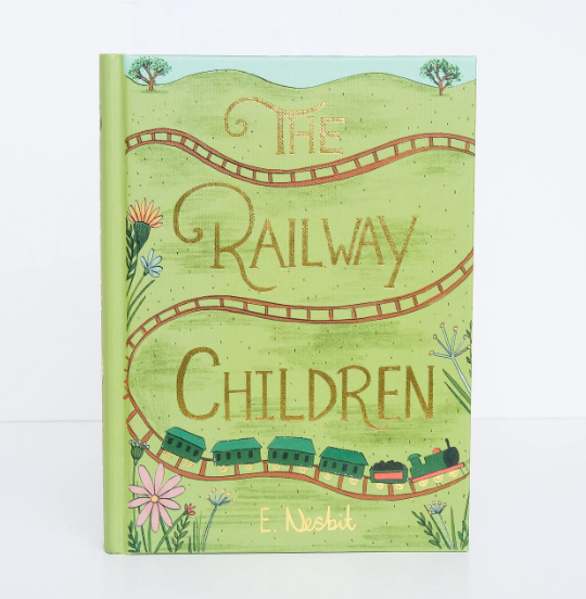 The Railway Children | Collector's Edition | Hardcover features a green cover with gold lettering, a winding railway track, a green train, hills, and colorful flowers. Authored by Edith Nesbit.