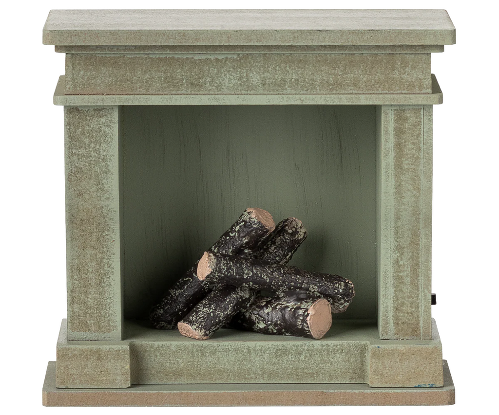 The PRE-ORDER: Fireplace, Miniature - Dusty Green (ships early October) is a small, rustic green-painted wooden fireplace with a vintage finish and short round firewood logs stacked inside the open firebox.