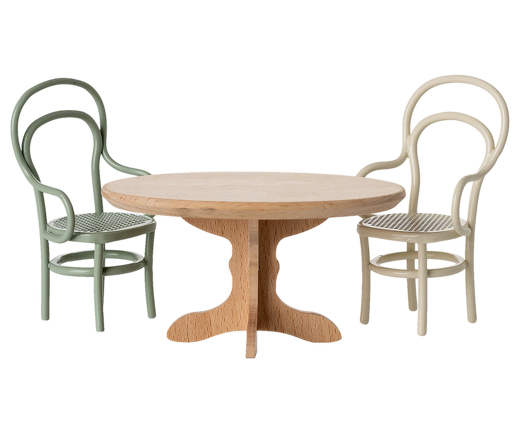 The PRE-ORDER: Oval Dining Table, Mouse - Nature (ships early October) features quality craftsmanship and pairs beautifully with two bentwood chairs in green and cream, both with curved backs and cane seats—ideal for cosy dinner parties.