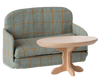 The PRE-ORDER: Sofa Bed, Mouse - Checker (ships late September), with its compact, foldable design and checkered pattern, pairs perfectly with a round, light wooden coffee table for any SuitCasa living room.