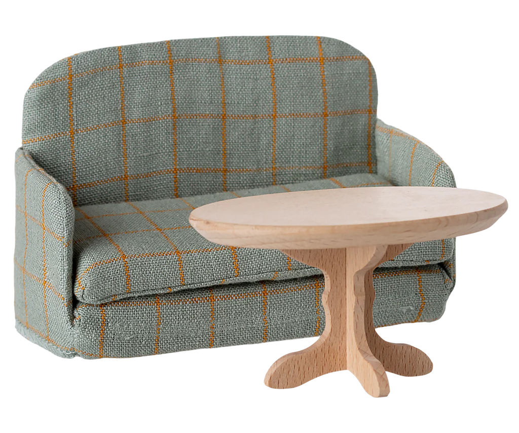 The PRE-ORDER: Sofa Bed, Mouse - Checker (ships late September), with its compact, foldable design and checkered pattern, pairs perfectly with a round, light wooden coffee table for any SuitCasa living room.