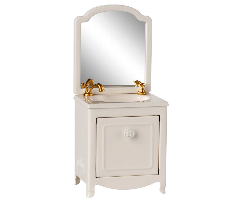 PRE-ORDER: Sink Dresser, Mouse - Off White features a small sink, gold faucet, cabinet door, and mirror—ideal for storing bathroom essentials in any Mouse hole Farmhouse. Estimated ship date: early September.
