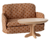 The PRE-ORDER: Sofa Bed, Mouse - Dots (Estimated Ship Date: Late September) features a tan and brown polka dot pattern, making it a charming SuitCasa living room accent or cozy sofa behind a round, light wooden pedestal table.