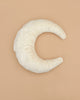 The Senger Naturwelt - Moon Nursing and Neck Pillow, crafted with GOTS-certified materials and covered in white fabric, is shaped like a soft crescent moon and placed on a plain beige background.