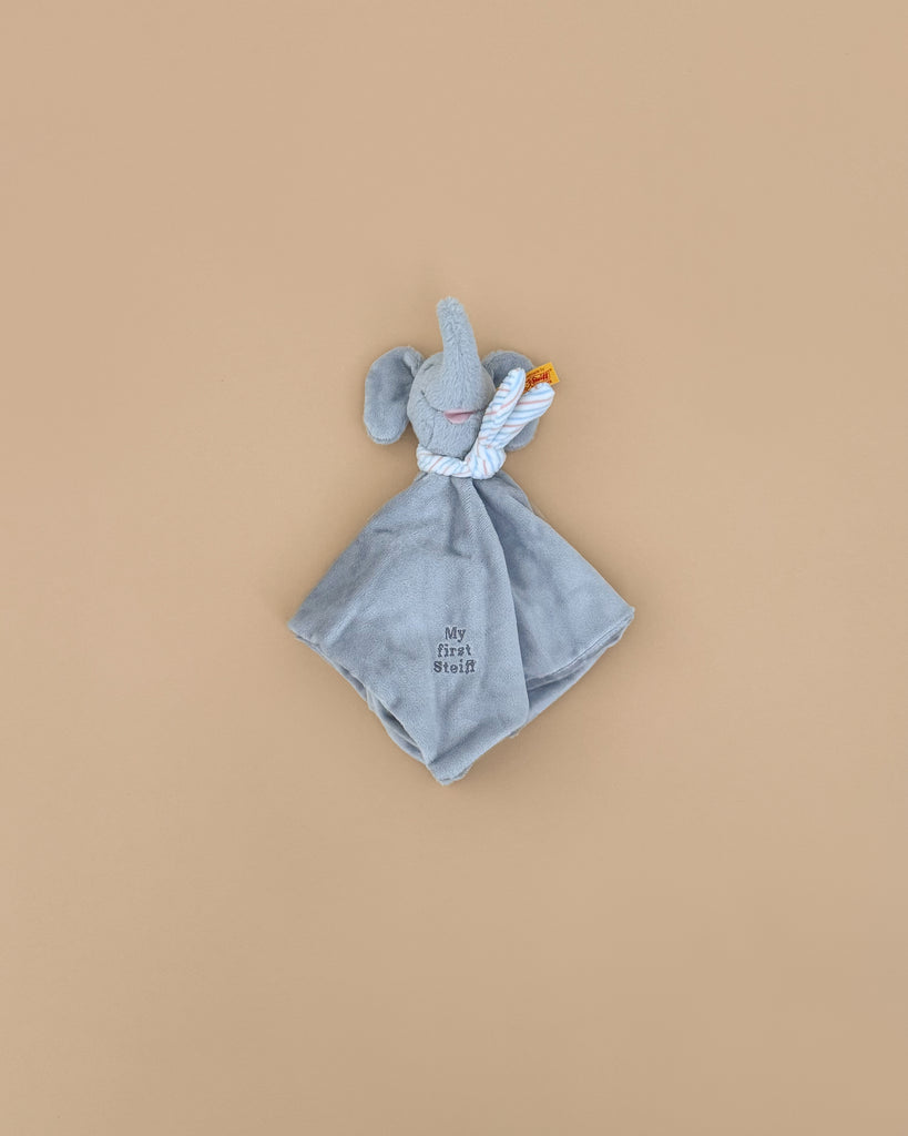 The “My First Steiff” Ellie Elephant Security Blanket Baby Toy, 10 inches, is a soft gray comforter with embroidered lettering—ideal for babies. Shown against a plain beige background.