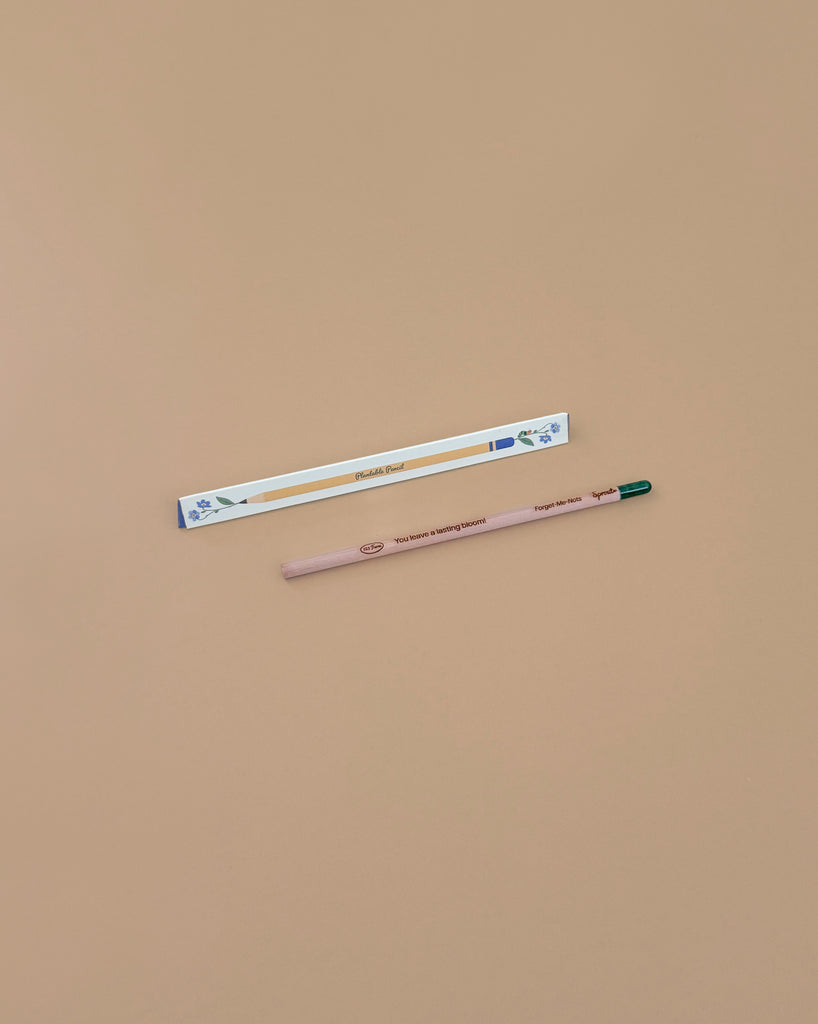 A pregnancy test and a Tomatoes Plantable Pencil – Eco-Friendly with a green eraser are placed on a plain beige surface. The pencil, ideal for growing cherry tomatoes, sits below the pregnancy test.