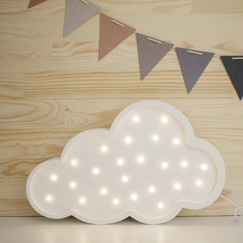 The Handmade Wooden Lamp - White Cloud, featuring glowing bulbs, rests on a pinewood-patterned surface against a light wood wall adorned with pastel and dark triangular pennants.