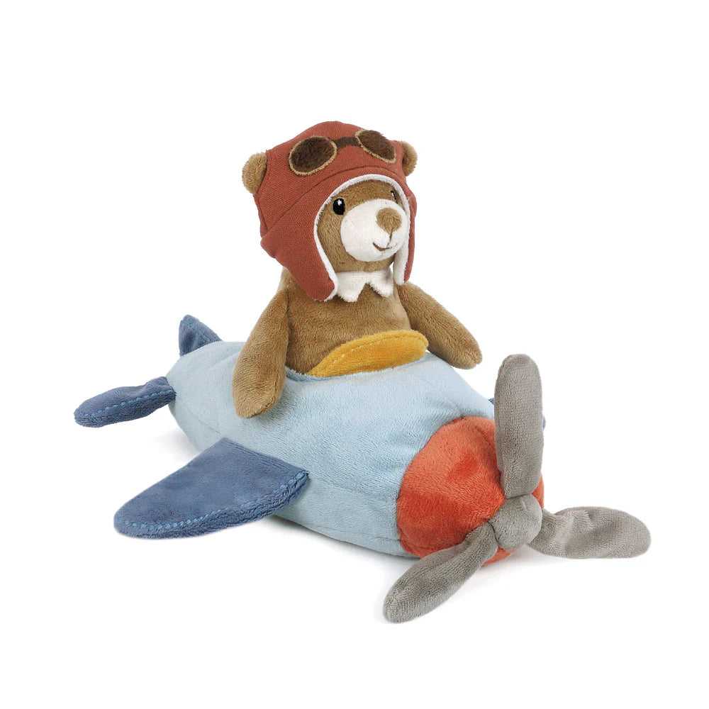 The Pilot Bear Plush Toy wears a brown aviator hat with embroidered goggles and sits on a blue and red vintage propeller airplane with gray wings.