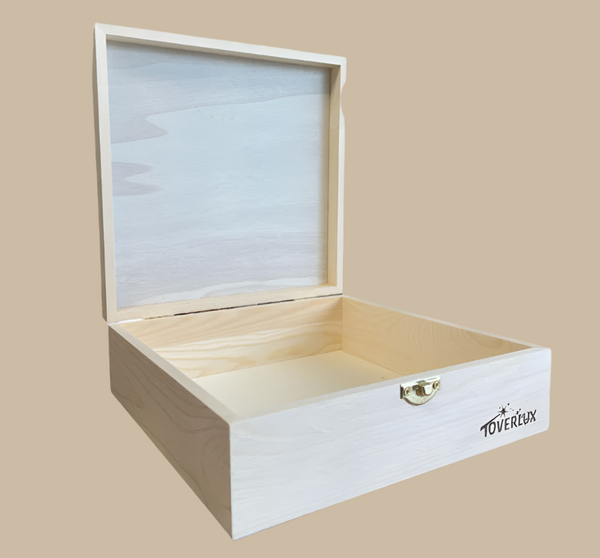 The Toverlux Silhouette Storage Box is a plain, light-colored wooden box with a closable lid, shown open to reveal an empty interior. It features a small gold clasp and "Toverlux" printed on the front corner.