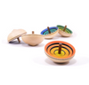 The Mader UFO Flora Spinning Top - Green, crafted from maple wood with vibrant concentric circles, rests on a white surface. This toy meets rigorous safety standards and features green as its standout color.