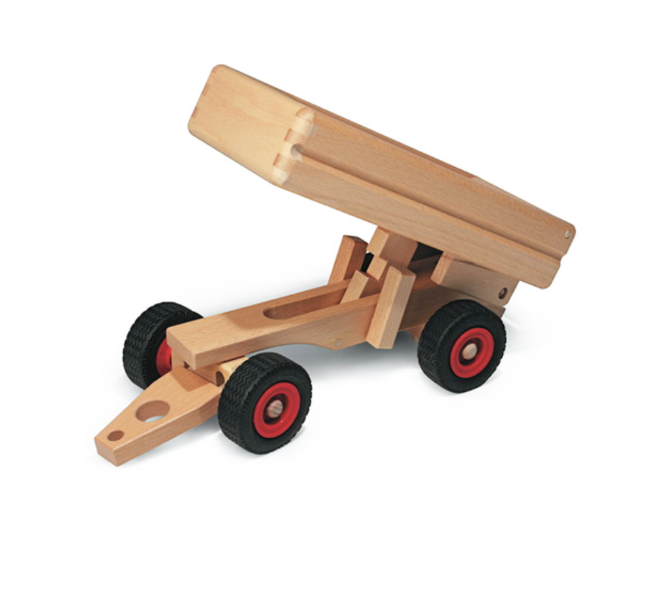 The Fagus Wooden Dump Trailer is a handcrafted wooden toy with black wheels, red hubs, and a tilting bed—ideal for pretend construction. Shown on a white background.