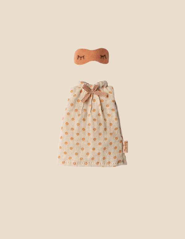 A small beige Maileg Extra Clothing: Nightgown For Mom Mouse, with orange polka dots and a bow at the neck, plus a matching orange nightgown-style eye mask with embroidered closed eyes, displayed on a plain beige background.