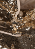 Close-up of the Konges Sloejd Sparkly Doll Pram - Golden Cherry, featuring shiny gold sequins, a snap button closure, and a beige interior—an eye-catching accessory to pair with your favorite vintage-style pram.