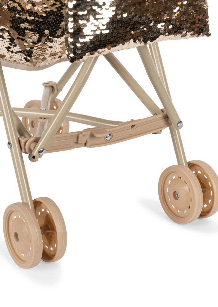 Close-up of the lower part of the Konges Sloejd Sparkly Sequin Doll Stroller - Golden Cherry, featuring four plastic wheels and a gold sequin-covered seat.