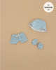 Green Tea terrycloth 3-piece swimsuit set by Emile & Ida for 13-inch Minikane dolls, featuring shorts, a bucket hat, and matching booties, styled on a beige background.