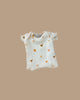 The Minikane Doll Clothing Les P'tits Basique Ribbed Bodysuit in Hearts is a beige, cream-colored short-sleeve onesie made from soft cotton with golden and brown heart patterns for Minikane 13" & 14" dolls. Designed in France, it fits Gordis dolls.