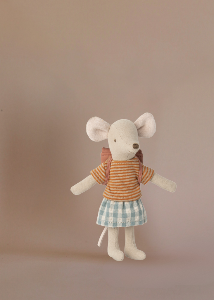 A Maileg Afternoon Tea With Grandma And Grandpa set features the Big Sister mouse with a yellow and orange striped shirt, blue and white checkered skirt, and pink backpack against a plain beige background.