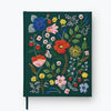 The Strawberry Fields Embroidered Sketchbook is a dark green hardcover journal with colorful floral, leaf, strawberry, and butterfly embroidery in red, pink, blue, and yellow on the cover.