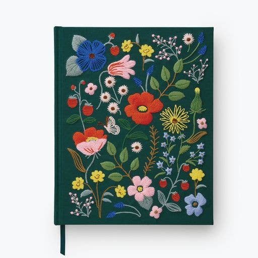 The Strawberry Fields Embroidered Sketchbook is a dark green hardcover journal with colorful floral, leaf, strawberry, and butterfly embroidery in red, pink, blue, and yellow on the cover.
