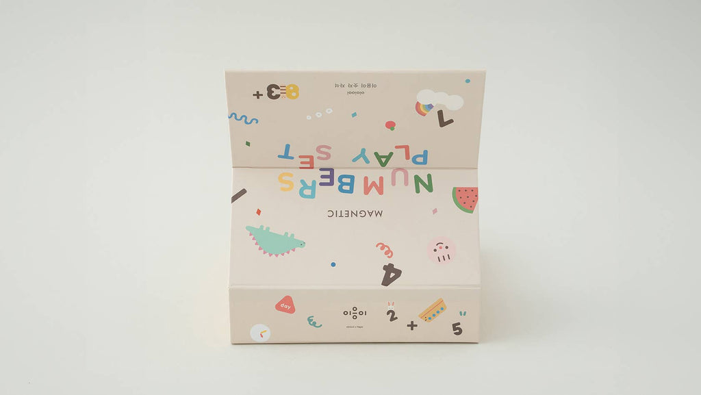 A beige box labeled "Magnetic Number Play Set" with colorful letters, numbers, shapes, and a watermelon slice sits upside down on a white background—ideal for anyone who enjoys magnet puzzles.