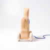 Grimm's Horse Holly is a charming wooden pull-along horse toy with white wheels and a blue string, shown against a plain white background—a timeless classic for toddlers.