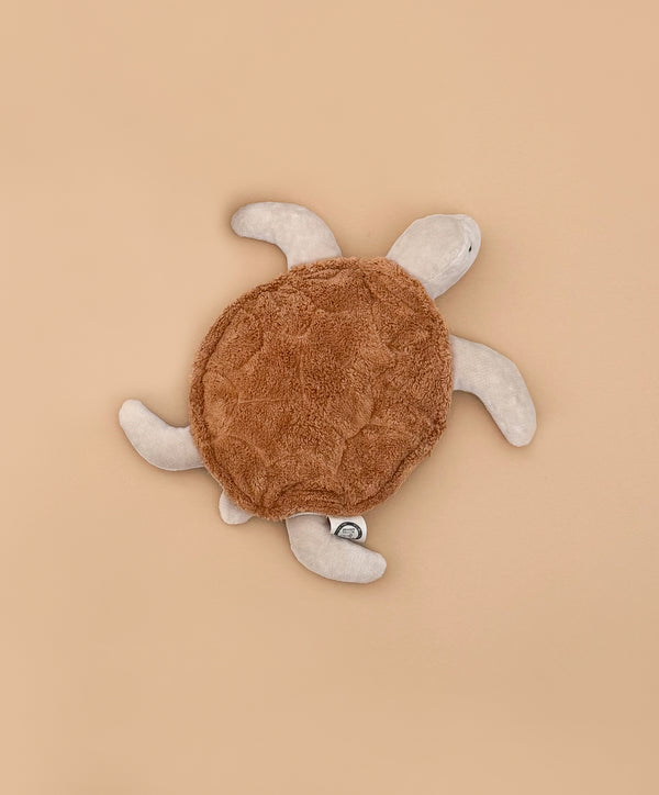 The Senger Naturwelt Cuddly Animal - Turtle, with a soft brown shell and beige flippers, made from organic cotton as a grain pillow, is displayed on a plain light brown background.