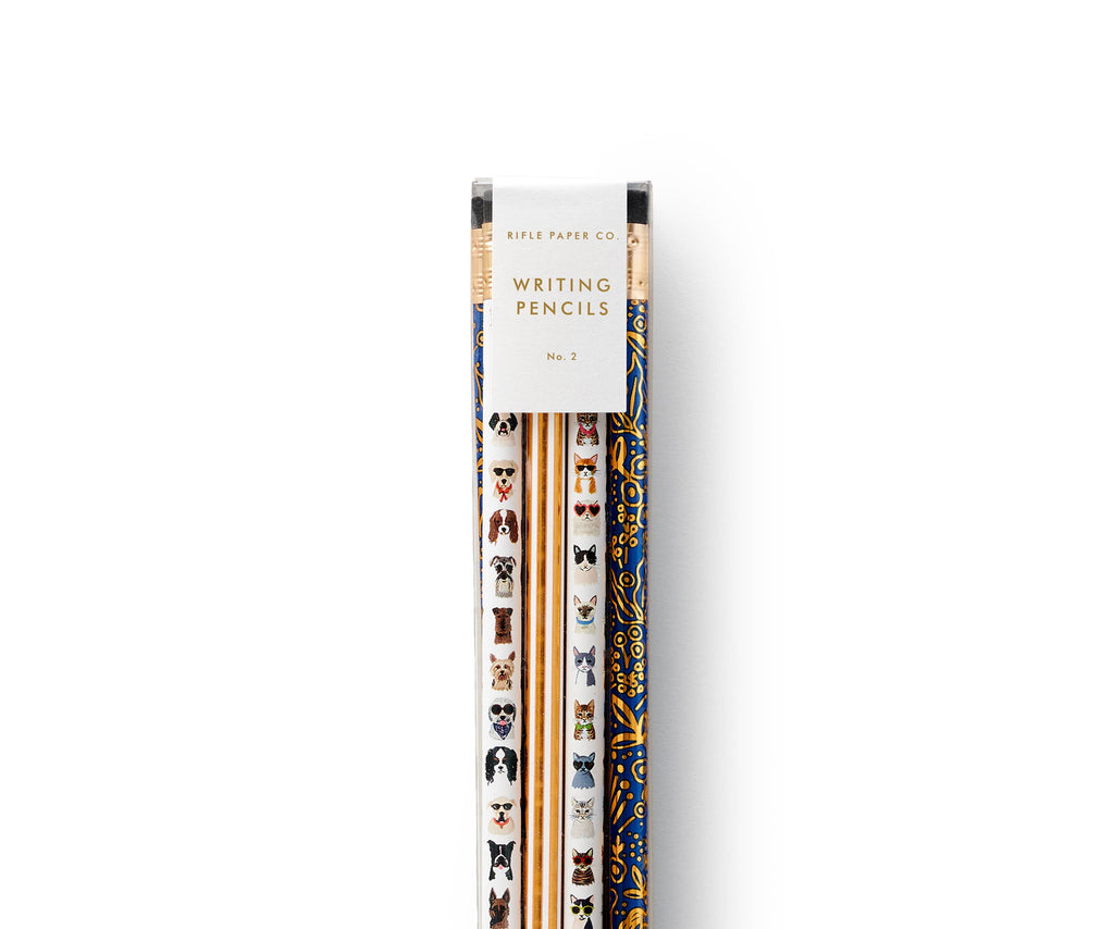 The Cats & Dogs Pencil Set by Rifle Paper Co. includes illustrated pencils—white with playful dog faces and navy with a charming floral pattern—displayed on a white background.
