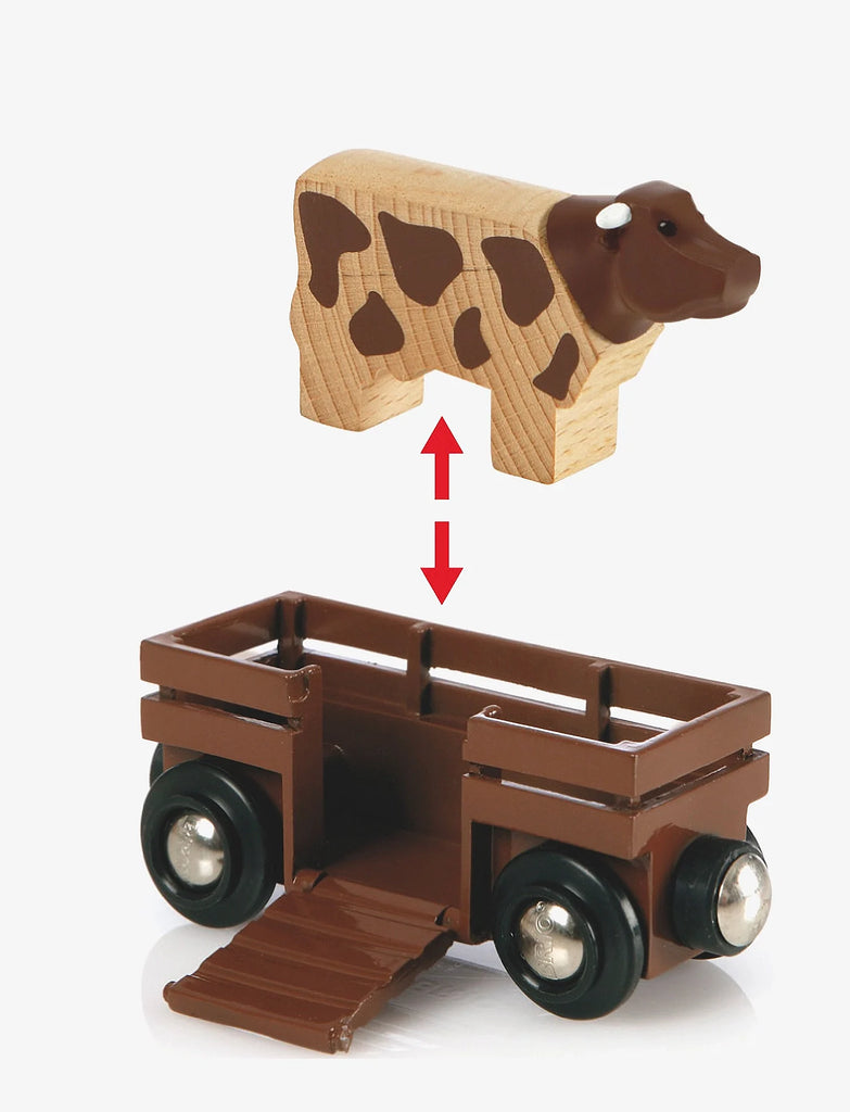 A wooden toy cow hovers above a brown trailer with an open ramp. A red double-headed arrow shows the cow can go inside—perfect for imaginative play with your BRIO World Train Set Farm Railway Set.