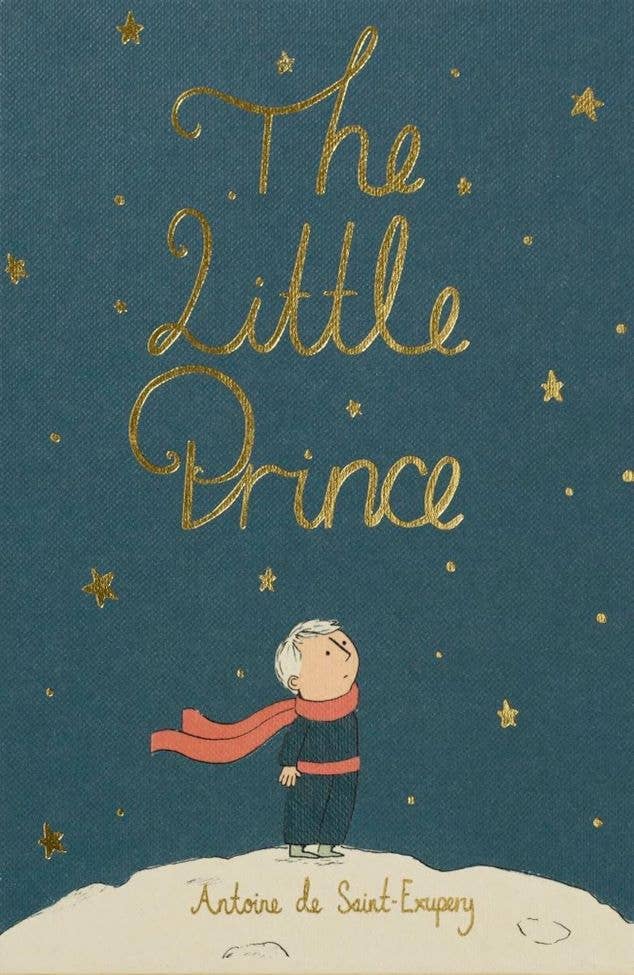 The cover of The Little Prince | Collector's Edition | Hardcover features a blond boy in blue clothes and a red scarf on a white hill, looking at golden stars beneath the gold-script title, with the author's name shown at the bottom.