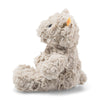The Steiff Honey Teddy Bear Stuffed Plush, 8 inches, is a soft, light brown bear with curly fur, dark eyes, and an ear tag. It sits upright in profile facing left against a white background—a classic children’s toy.