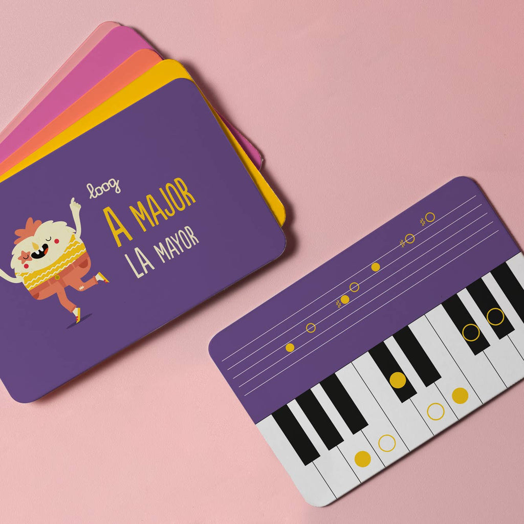 Two colorful Loog Piano music flashcards on a pink background—one shows a cartoon and "A Major / La Mayor"; the other displays velocity-sensitive keys and notes, perfect for learning chords on your portable digital piano.
