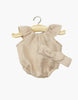 The Minikane Doll Clothing | Clara Romper & Headband in Washed Linen - Nude features a light beige romper with ruffled sleeves and a matching bow headband, displayed on a wooden hanger—perfectly sized for Minikane dolls.