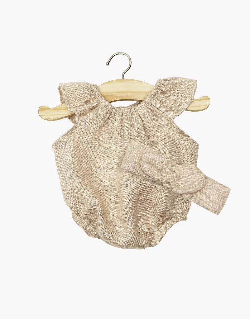 The Minikane Doll Clothing | Clara Romper & Headband in Washed Linen - Nude features a light beige romper with ruffled sleeves and a matching bow headband, displayed on a wooden hanger—perfectly sized for Minikane dolls.