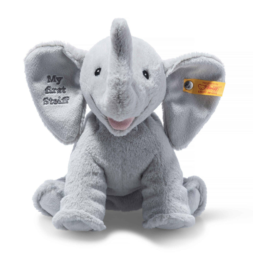 The “My First Steiff” Ellie Elephant Plush Baby Toy, 9 Inches, features soft gray plush, large embroidered ear with “My First Steiff,” a friendly face, and signature yellow tag—an ideal keepsake for any baby.