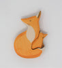 Handmade Wooden Snuggling Foxes: a sustainable hardwood toy puzzle with an orange fox and a smaller fox nestled inside, both featuring simple painted details and finished with natural, non-toxic stains. Set against a plain white background.