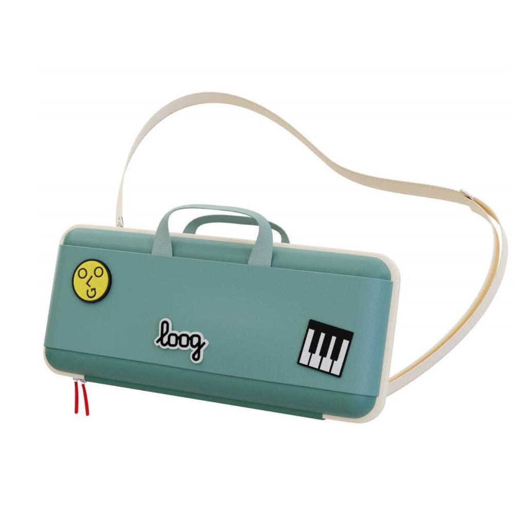 The Loog Piano Carrying Case is teal and rectangular, featuring a cream handle, adjustable straps, a smiley face print, "loog" text, and a piano key sticker.