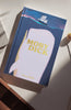 The "Moby Dick | Melville | Collector's Edition | Hardcover," with a pink whale and sailing ship on the cover, rests on a sunlit white surface.
