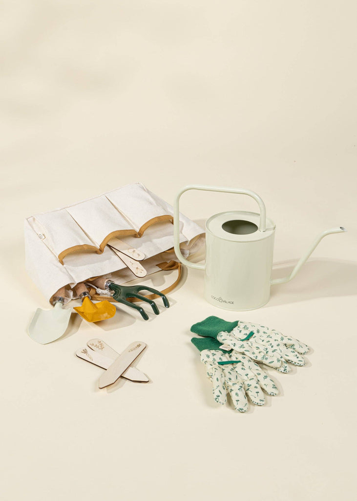 The Gardening Tools Playset includes a white tool bag, pale green watering can, floral gloves with green trim, yellow pruner, hand trowels, and labeled plant markers—perfectly arranged on a light background.