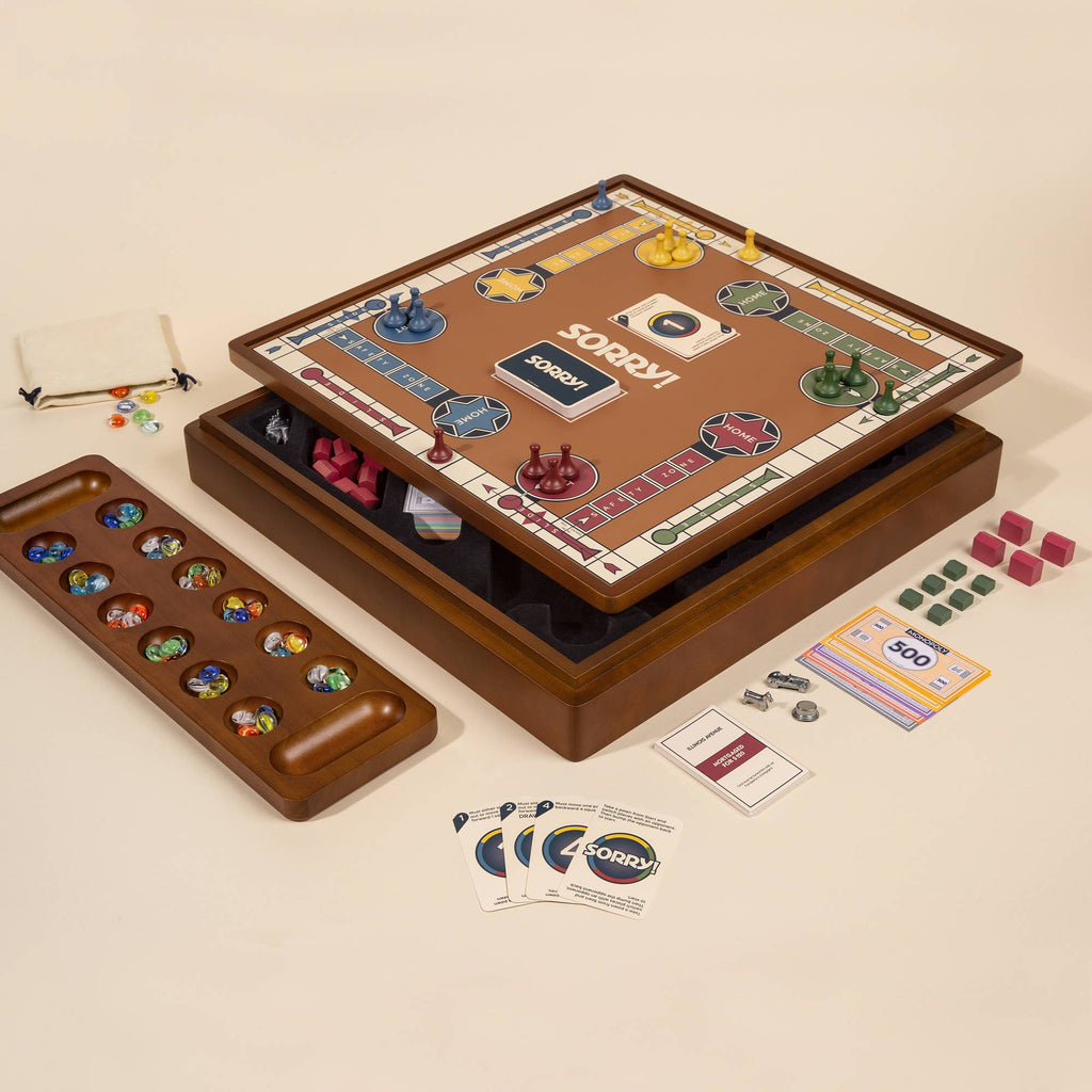 The 3-in-1 Game Collection features Monopoly, Sorry, and Mancala with pieces, cards, and tokens neatly arranged around the board on a cream-colored surface.