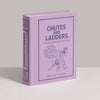 A lavender "Chutes and Ladders Vintage Bookshelf Edition" book stands upright, its cover featuring line drawings of children playing—reflecting the charm of this classic board game for ages 3 and up.