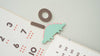 A pastel calendar with a green dinosaur magnet, brown circle and rectangle magnets clipped on top—perfect for pairing with the Magnetic Number Play Set or fun magnet puzzles.