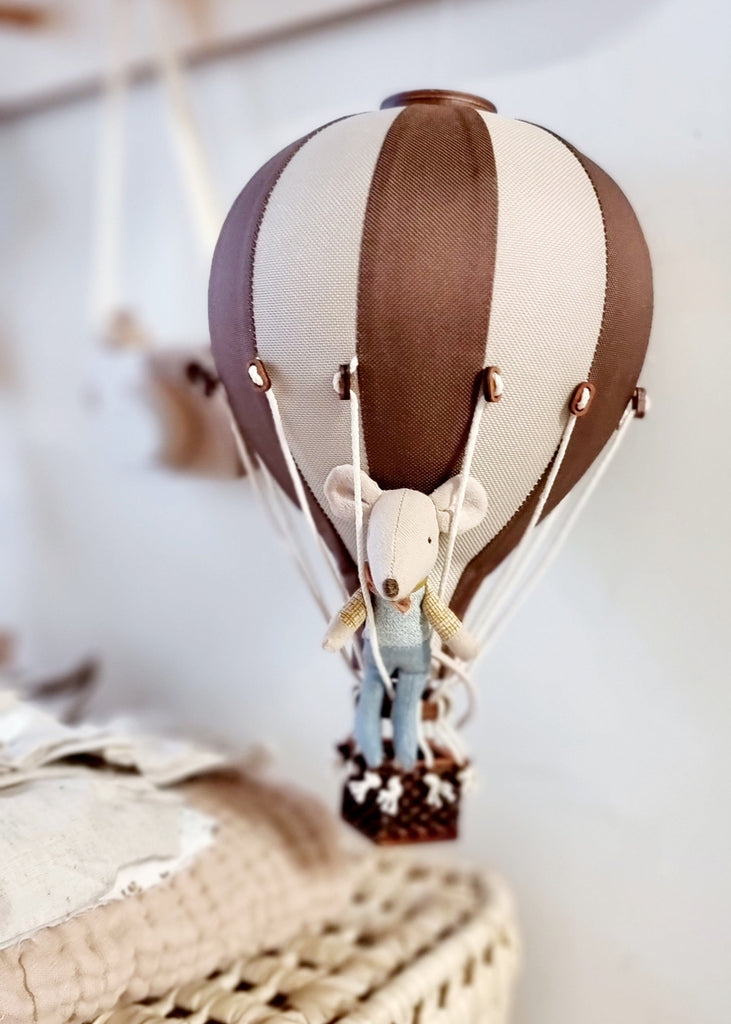 The Hot Air Balloon - Light Brown / Dark Brown features a small stuffed mouse in overalls sitting in a basket, making a charming indoor decoration for children's rooms.