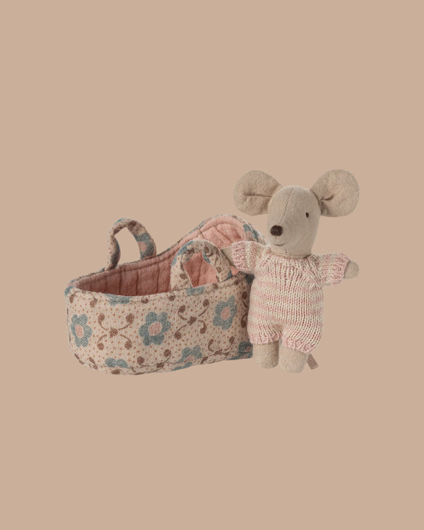 PRE-ORDER: Baby Mouse in Carry Cot - Rose. This tiny mouse wears a knitted suit and comes with a soft, patterned carry cot featuring rose designs and a handle. Estimated ship date is late October.